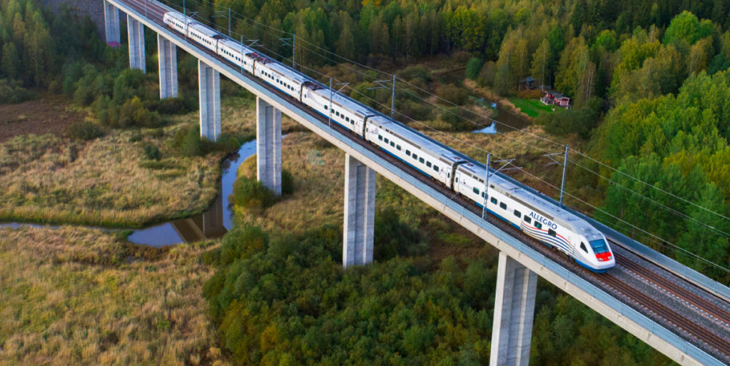 VR:n Allegro-juna ajamassa sillalla, ympärillä metsäinen peltomaisema