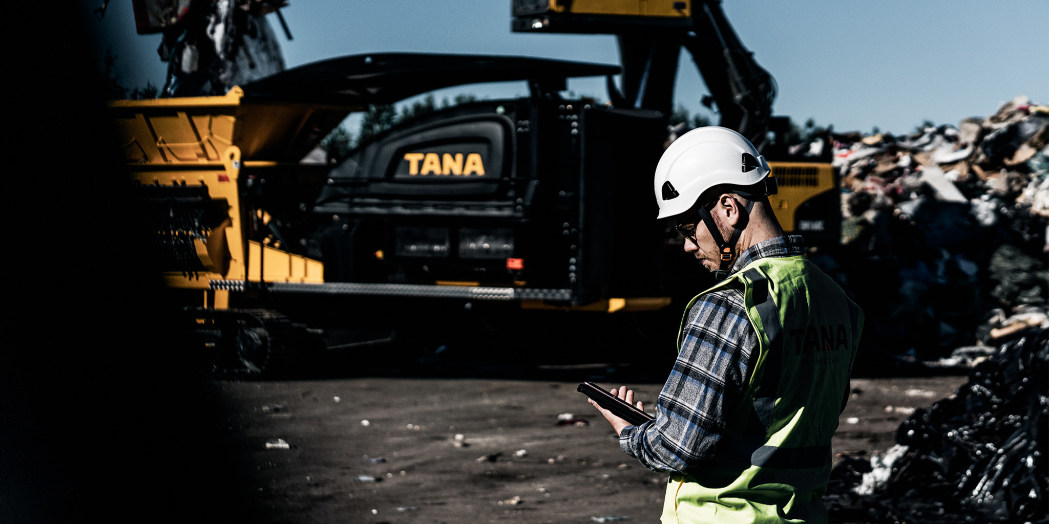 Tanan työntekijä töissä kaatopaikalla, taustalla Tanan kone